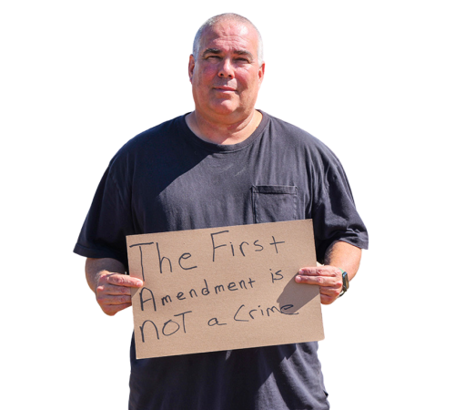 Jeff Gray holding a sign that reads "The First Amendment is Not a Crime"